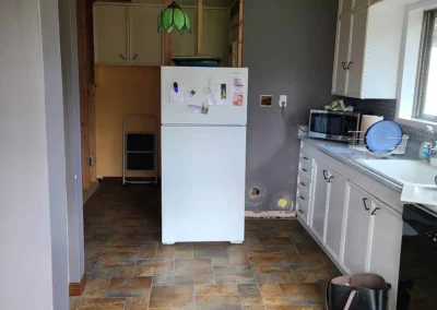 Redmond kitchen mid-demolition with the dropped ceiling opened up and original cabinets and flooring still in place