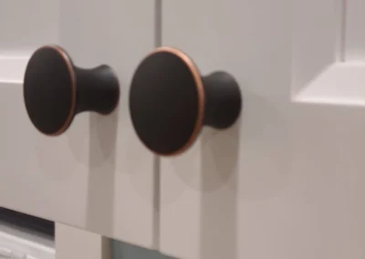 Close-up of oil-rubbed bronze cabinet knobs on white shaker doors in a Redmond kitchen