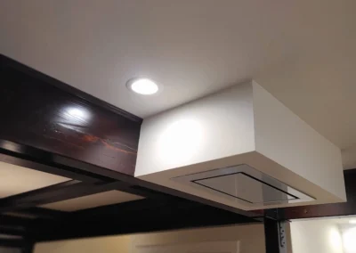Recessed ceiling range hood set into a white soffit with stained wood beam detail in a Redmond kitchen remodel