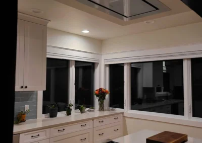 Recessed flush-mount ceiling range hood above the island cooktop in a Redmond kitchen remodel