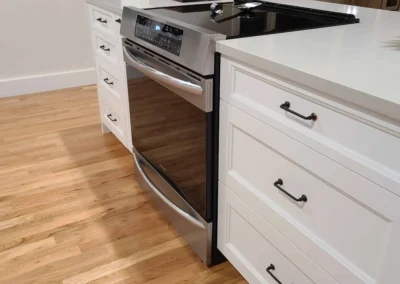 White island cabinetry with a stainless slide-in range over red oak hardwood flooring in a Redmond kitchen
