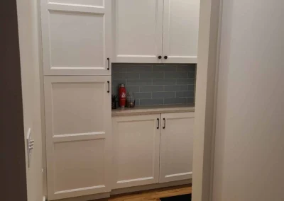 Tall white pantry cabinets with blue tile and quartz counter in a Redmond kitchen remodel