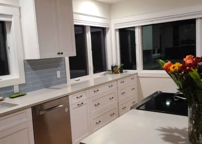 White shaker cabinets, blue glass tile backsplash, and quartz countertops in a Redmond kitchen remodel