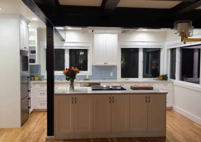 Full view of a Redmond kitchen remodel with taupe island, white cabinets, and dark coffered ceiling