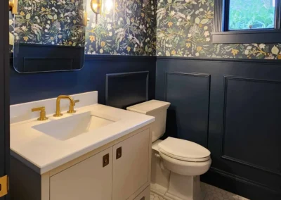 View into a luxury powder room featuring marble hexagon floor tile and deep blue architectural trim.