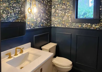 View into a luxury powder room featuring marble hexagon floor tile and deep blue architectural trim.